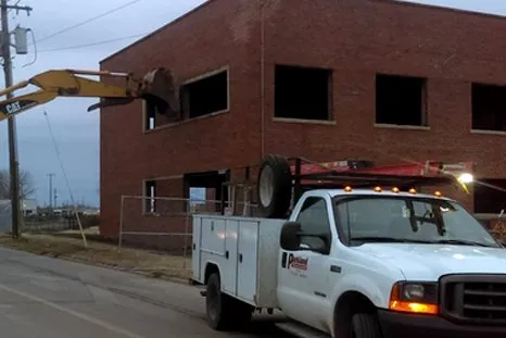 Worker destroying building with excavator